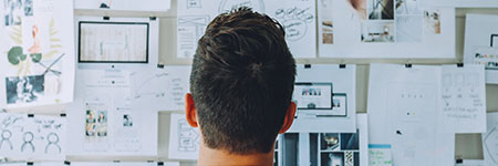 A man looking at documents on a wall